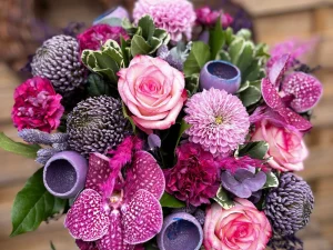 Bouquet d’anniversaire élégant de fleurs roses, fuchsias et violettes avec roses, orchidées et chrysanthèmes.