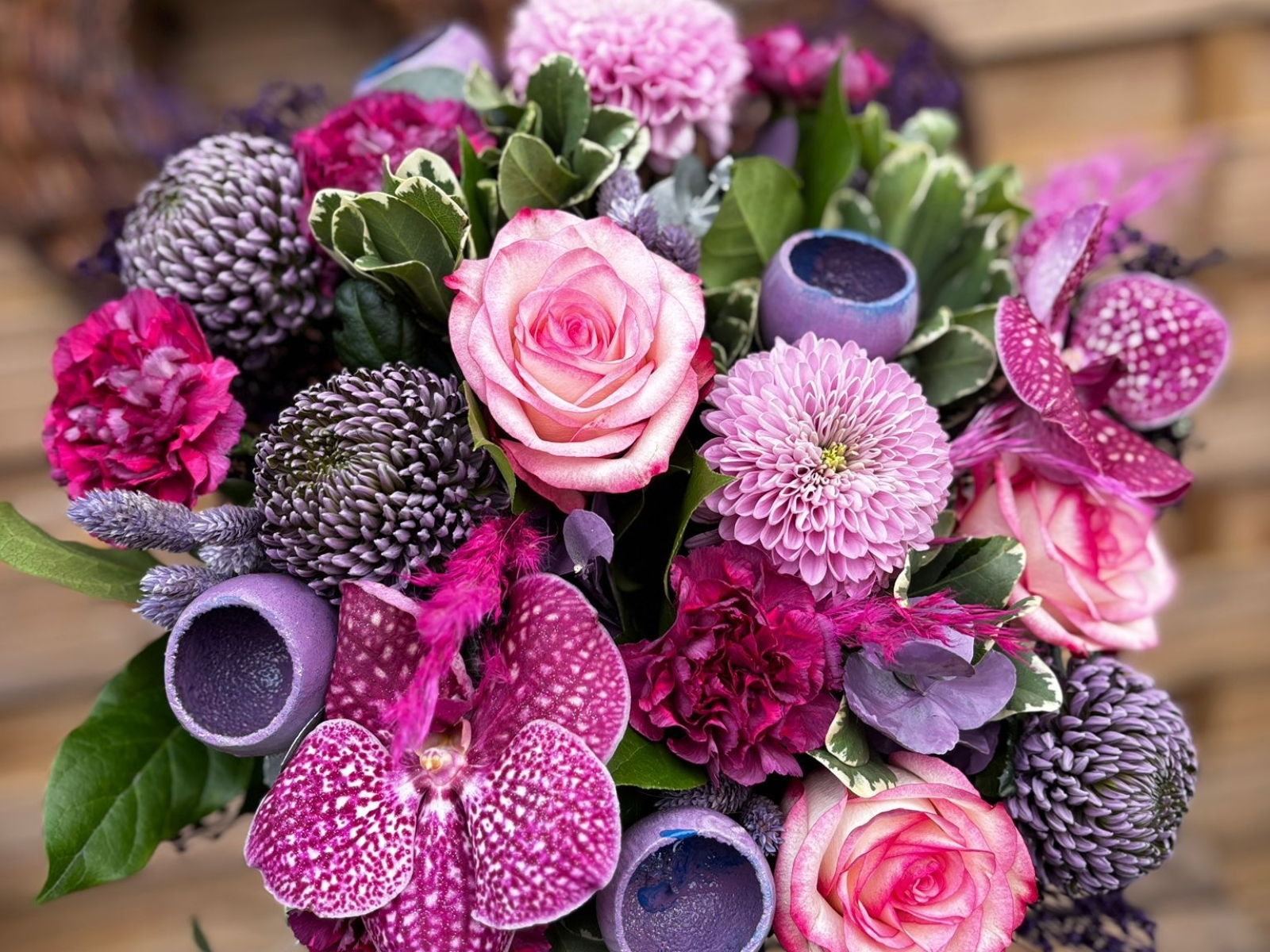 Bouquet d’anniversaire élégant de fleurs roses, fuchsias et violettes avec roses, orchidées et chrysanthèmes.